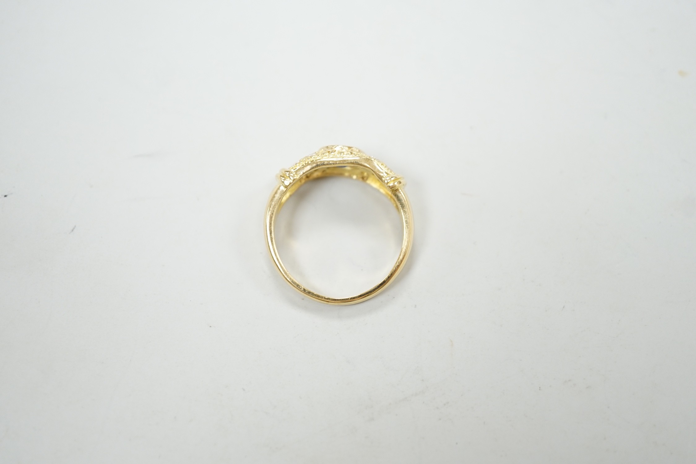 A modern 18ct gold, single stone oval cut sapphire and ten stone diamond chip set ring, size N/O, gross weight, 5.3 grams.